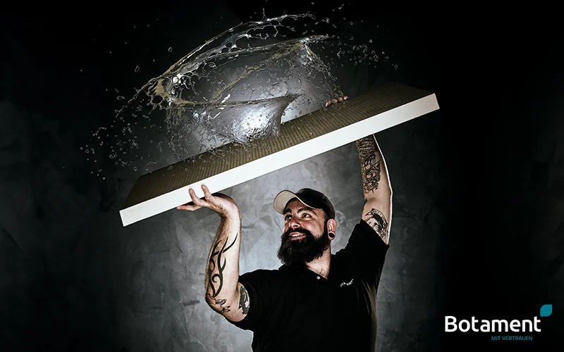 Handwerker mit Bauplatte in der Hand die Wasser abweist