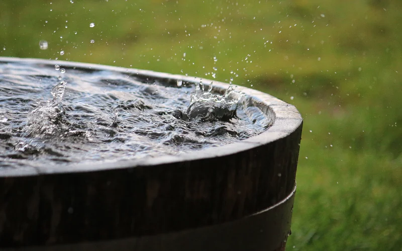 Regentonne aus Holz in die Wasser hineinplätschert