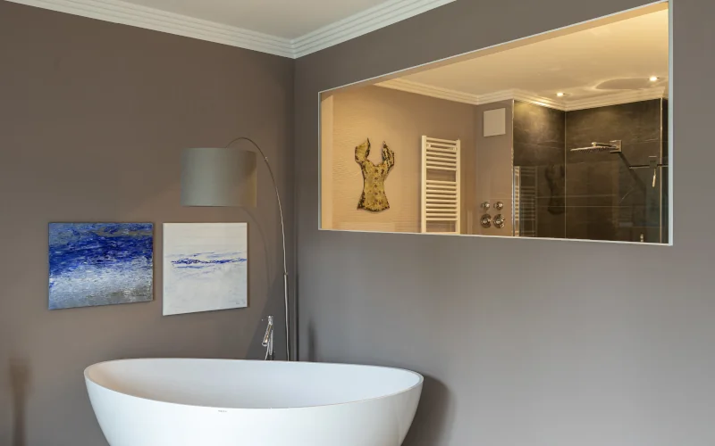 Badezimmer mit grauen Wänden und freistehender Badewanne