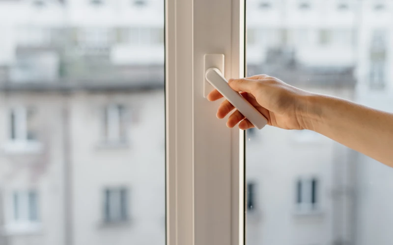 Hand die ein Fenster schließt