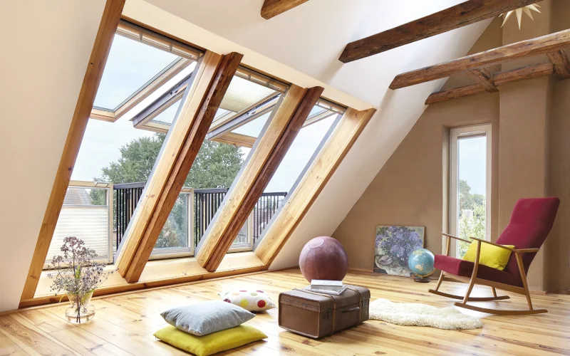 Wohnbereich im Dachgeschoss mit vielen großen Dachfenstern mit Holzrahmen
