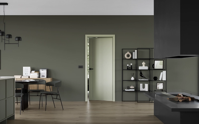 Wohnzimmer mit einer grünen Wand, einem offenen Kamin und einer weißen Tür im Hintergrund