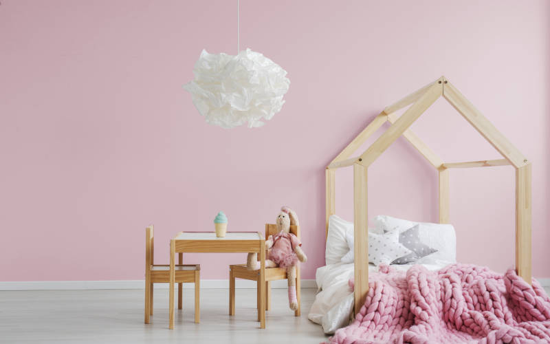 Kinderzimmer mit hellem Boden und rosa Wand