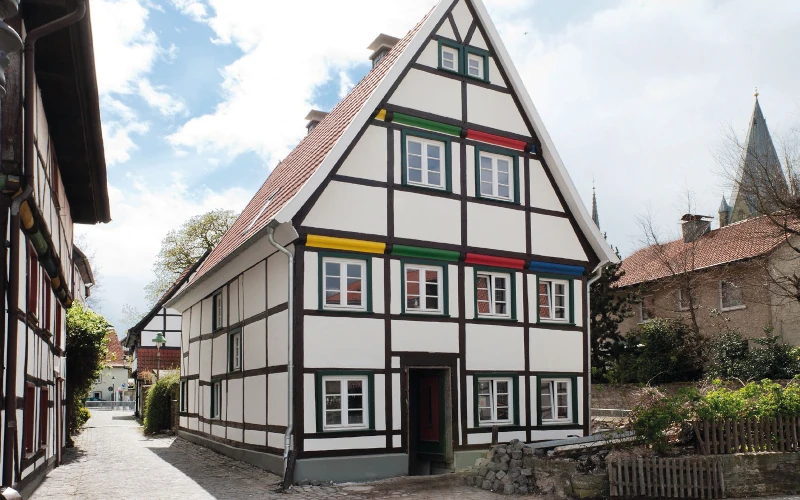 Fotoaufnahme von einem Haus mit weiteren Häusern im Hintergrund.