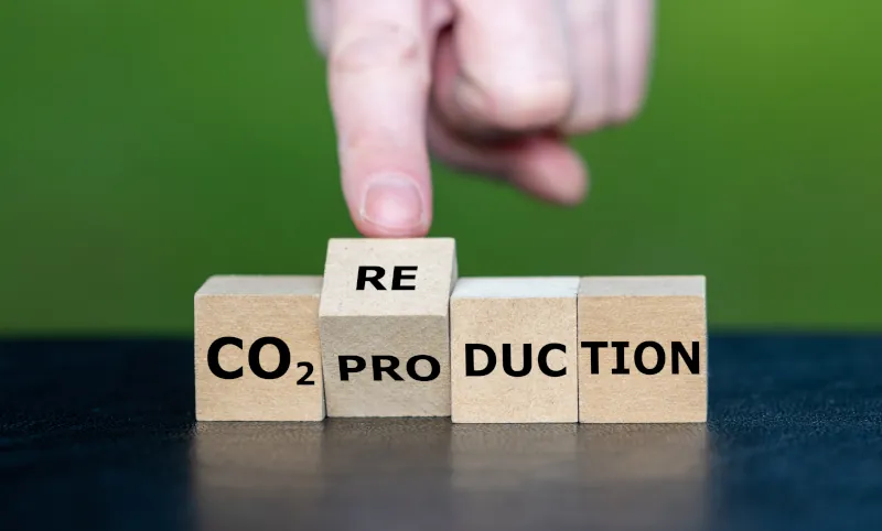Holzwürfel mit schwarzer Aufschrift CO2 Re/Pro-duction