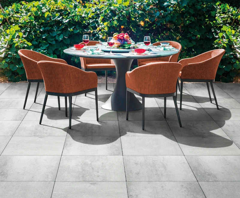 Sitzlounge im Garten auf hellgrauen Terrassenplatten