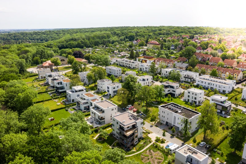 Luftaufnahme einer Kleinstadt mit viel Wald und Grünflächen
