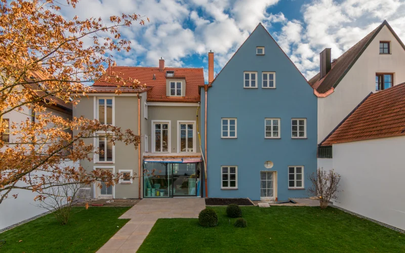 Reihenhaus mit blauer und grauer Fassade und vielen Fenstern