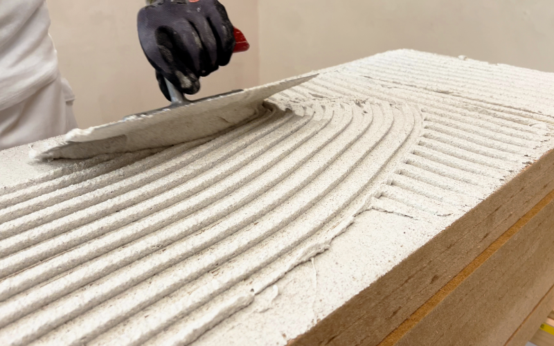 Handwerker trägt Spachtelmasse auf eine Holzfaser-Dämmplatte auf