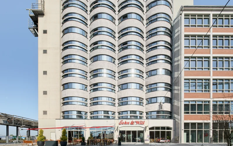 Hotel mit moderner rundgeschnittenen Fassadenelementen in grau mit vielen Fenstern