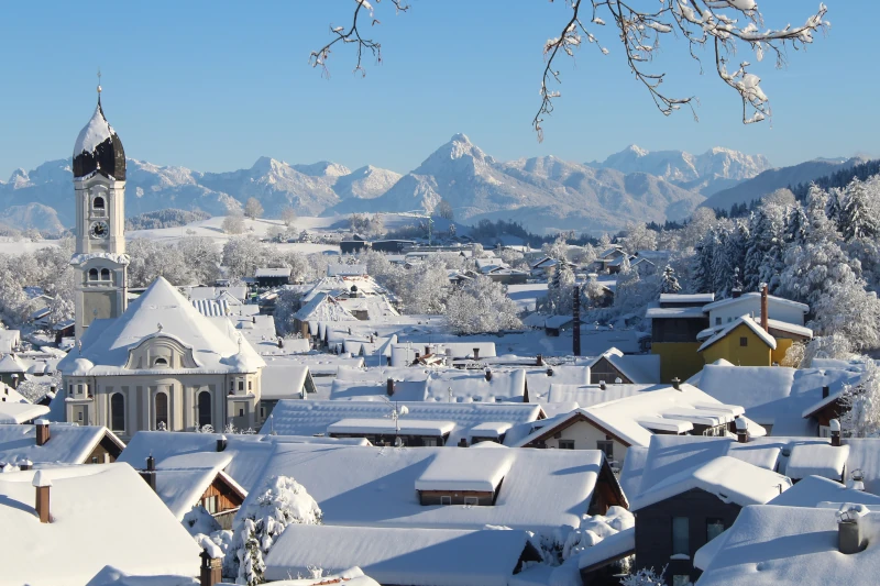 eingeschneite Stadt mit Bergen im Hintergrund