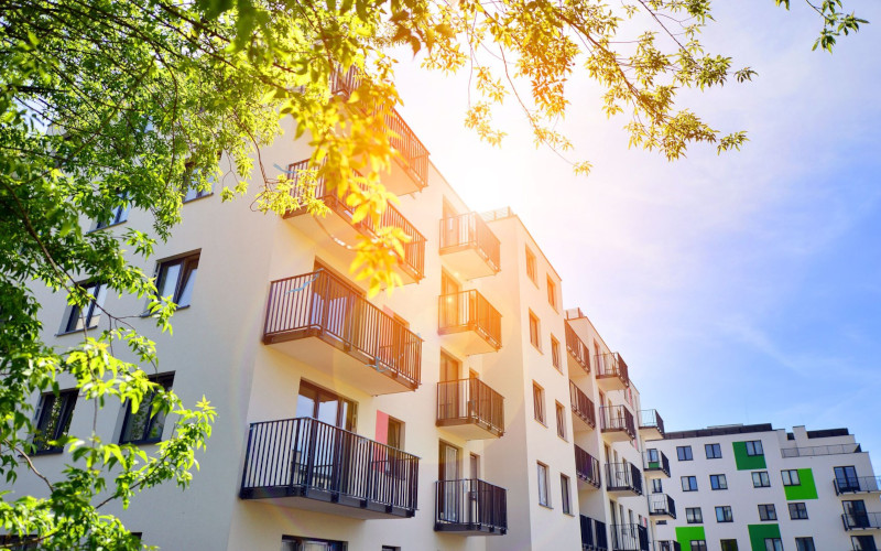 Frau steht neben einer Fassade zu einem Wohnzimmer