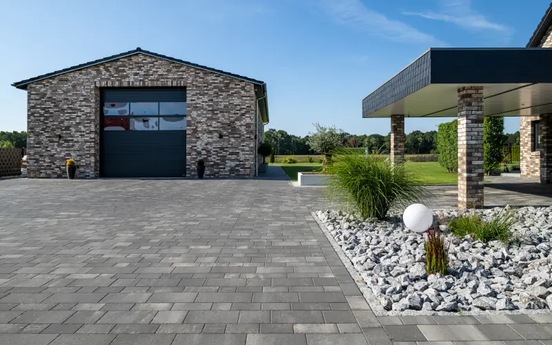 Grau gepflasterter Weg vor einer Garage