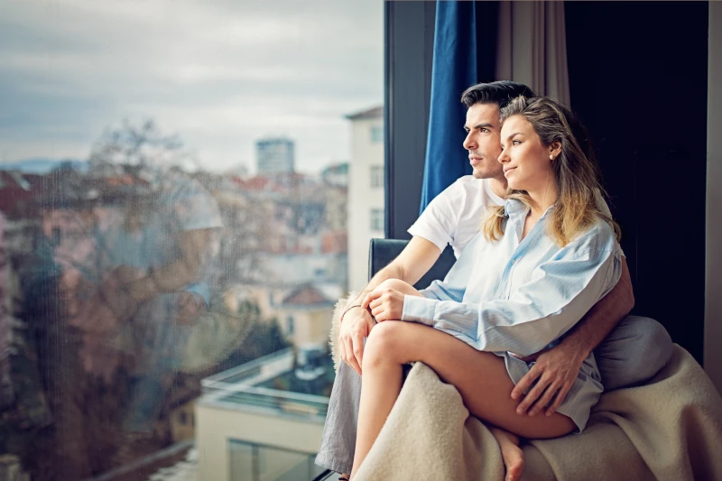 Paar sitzt am Fenster und schaut auf die Stadt