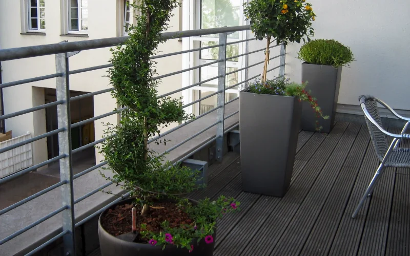 Stilvolle Dachterrasse mit Pflanzen in großen Töpfen und Möbeln.
