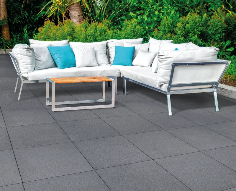 Sitzlounge im Garten auf dunkelgrauen Terrassenplatten