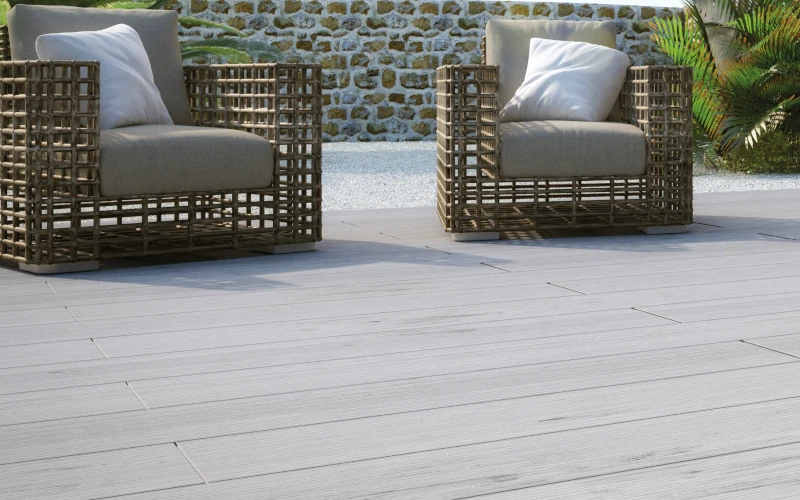 Terrasse mit hellgrauem Bodenbelag und zwei Sitzgelegenheiten
