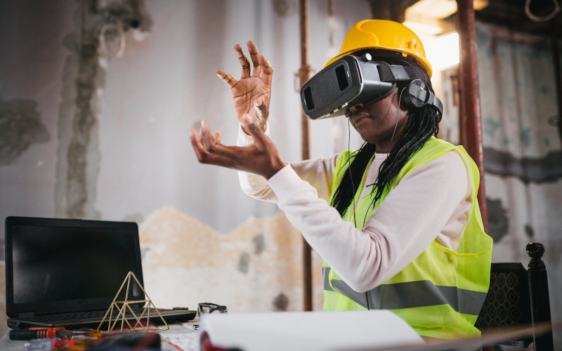 Frau mit aufgesetzter VR Brille auf einer Baustelle
