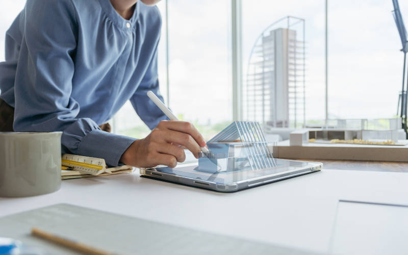 Architektin visualisiert ein Neubau über dem Tablet