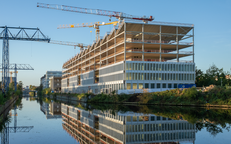 Baustelle eines modernen Bürogebäudes an einem Fluss