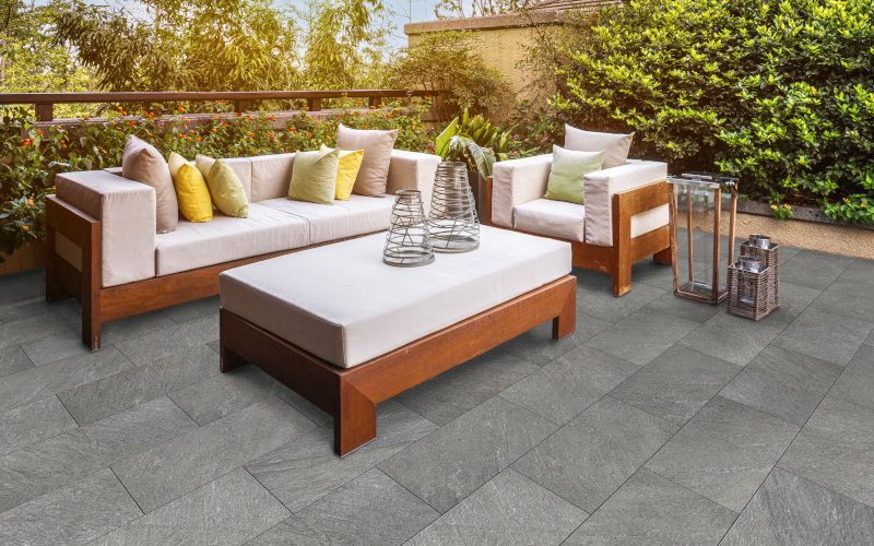 Sitzgelegenheit auf Terrasse mit grauen Pflastersteinen