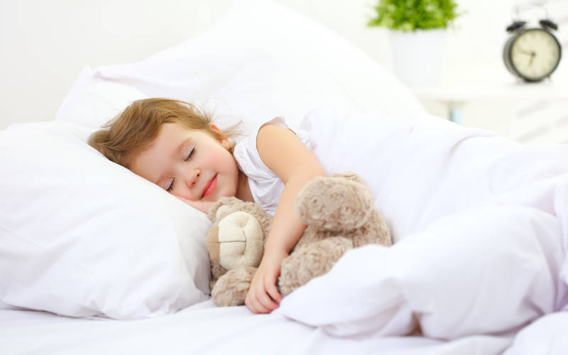 Kind schläft mit Kuscheltier