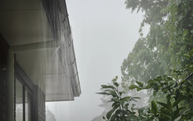 Hausdach mit Regenrinne bei Starkregen