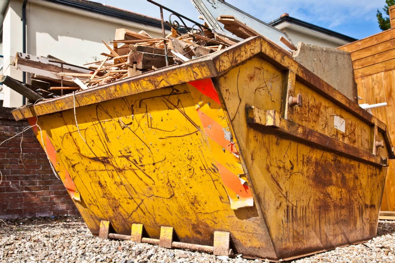 Gelber Müllcontainer auf Baustelle