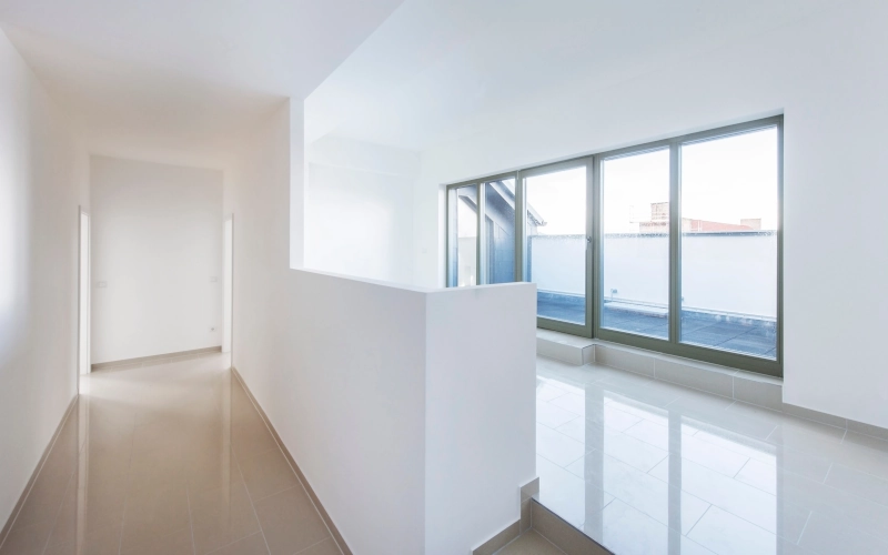 Leere Wohnung mit Fensterfront und Marmorboden