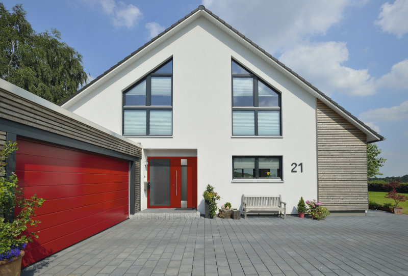 Einfamilienhaus mit Holzfassade und rotem Garagentor