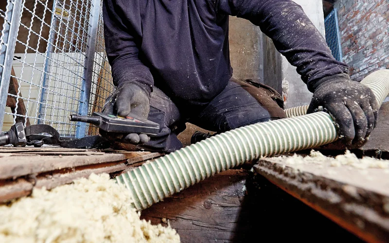 Handwerker gibt Einblasdämmung in Hohlraum