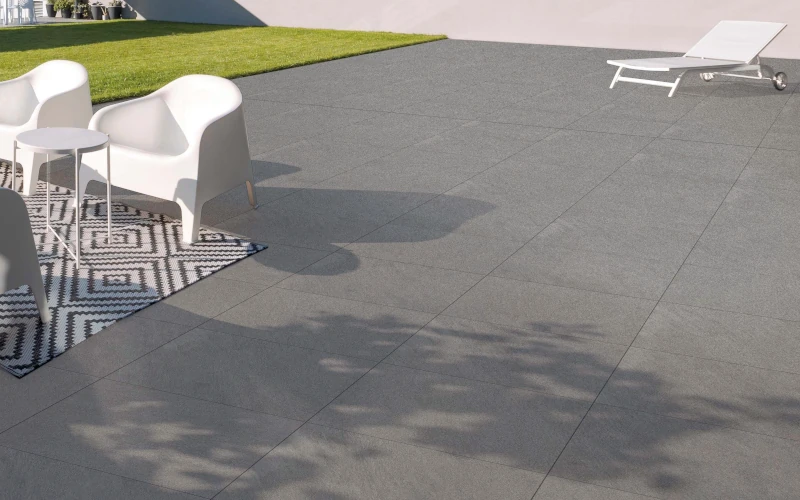 Terrasse mit grauen Platten und Sitzmöbeln