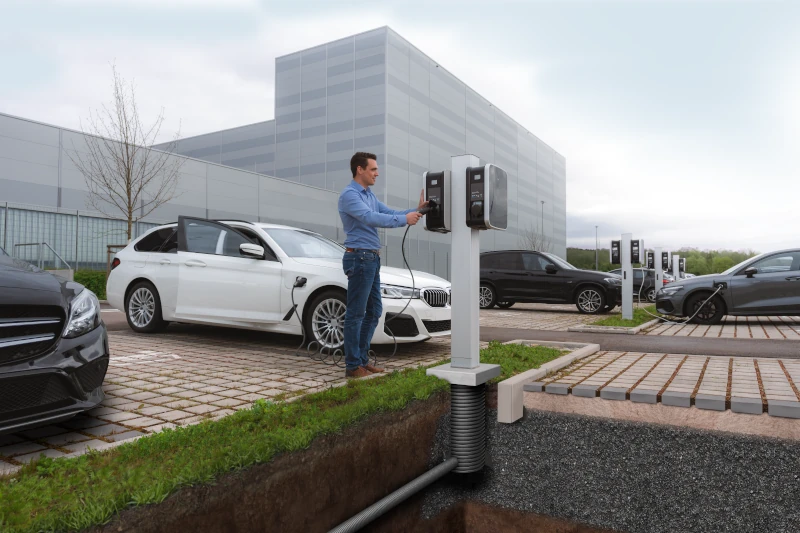 Mann bedient eine Ladestation für E-Autos