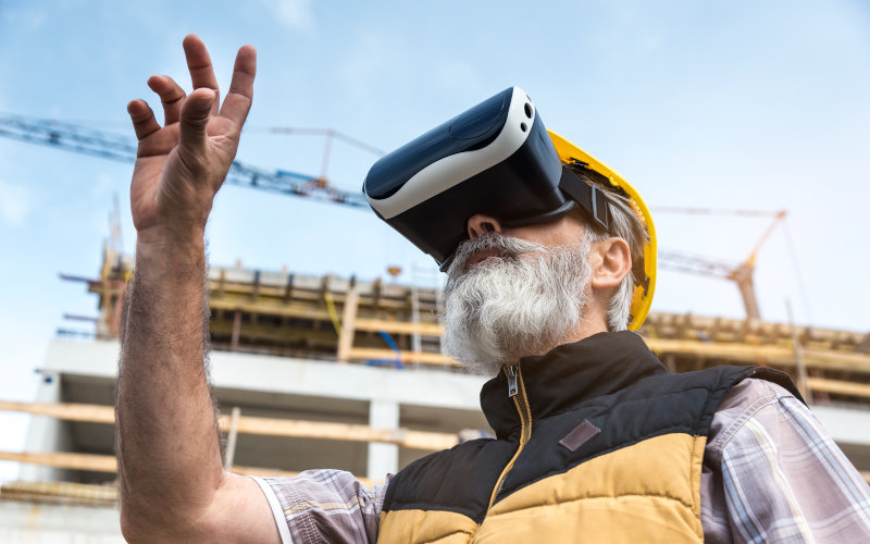Mann mit aufgesetzter VR Brille auf Baustelle