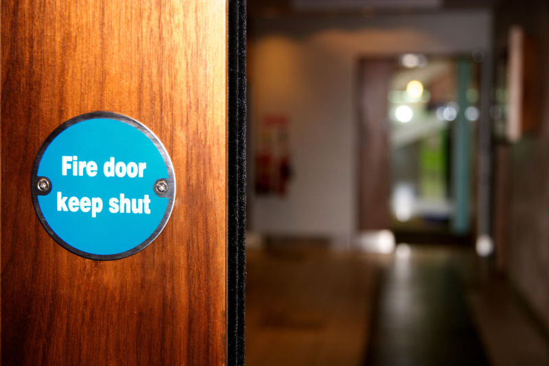 Fire door keep shut-Schild auf einer Tür