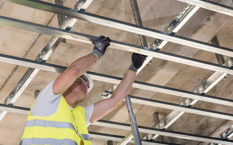 Arbeiter hängt Decken mit Tragprofilen ab