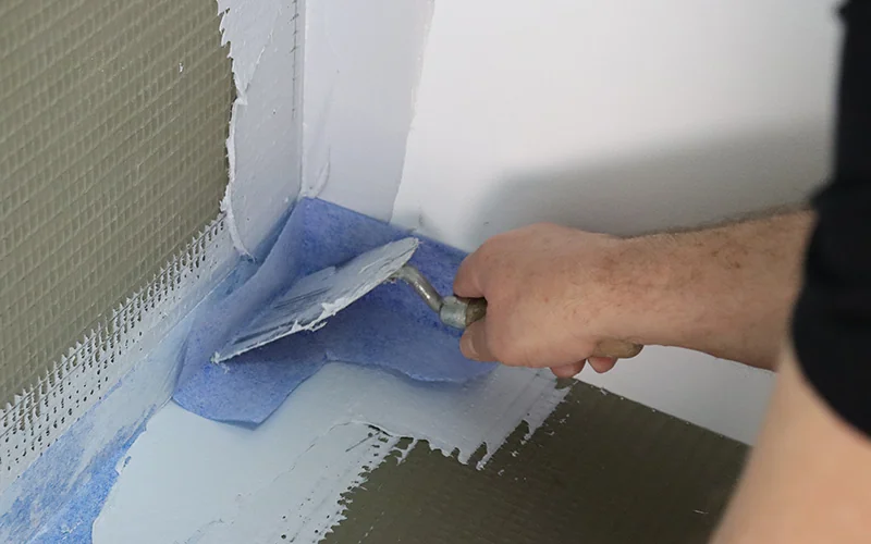 Handwerker verstreicht Masse mit einer Kelle