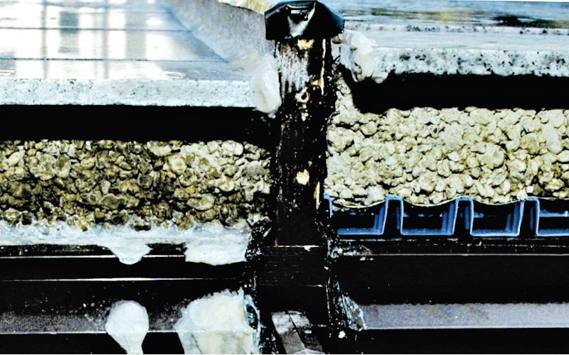 Querschnitt einer Dachkonstruktion mit Isolierung, Drainagesystem und verschiedenen Baumaterialien, technische Darstellung.