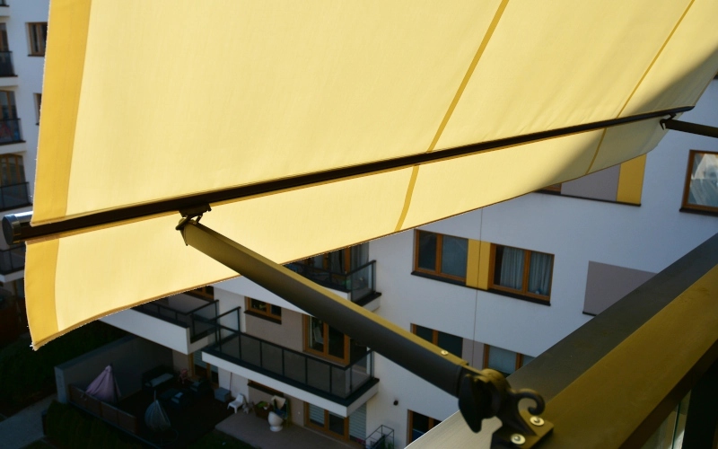Balkon mit geöffneter Markise, überdacht mit Sonnenschutz.