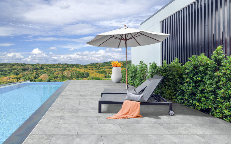 Helle graue Pflastersteine für eine Terrasse neben einem Pool