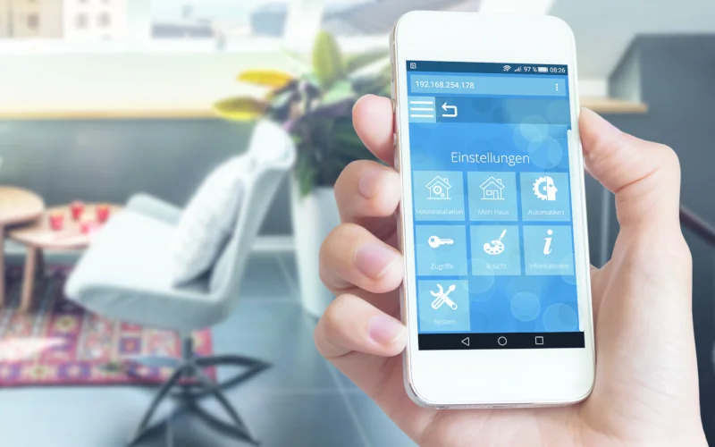 menschliche Hand hält Smartphone mit App-Steuerung in der Hand