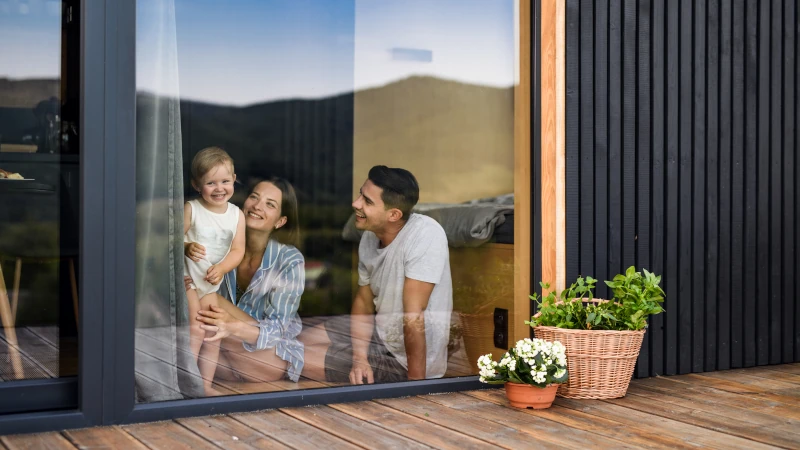 Familie im Haus steht an einem Fenster und freut sich