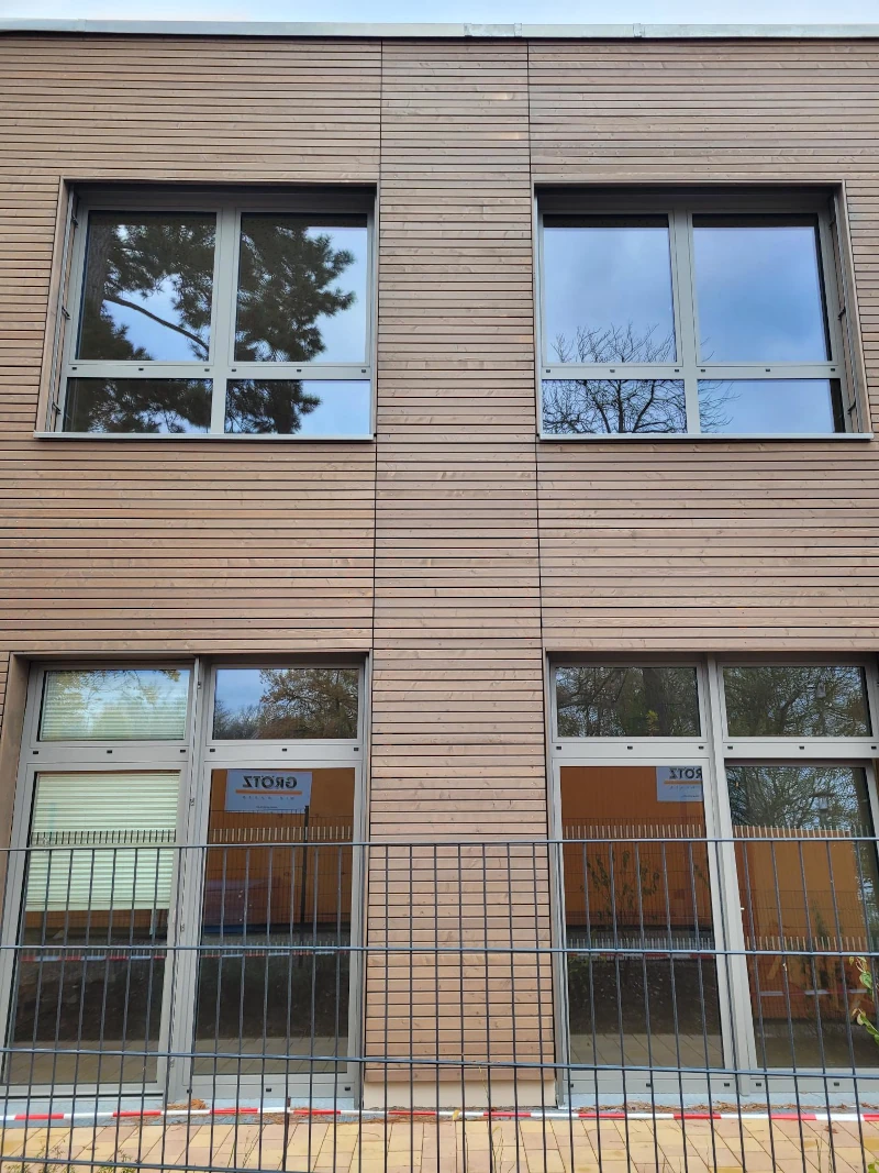 Ein Gebäude mit Holzfassade und Fenstern