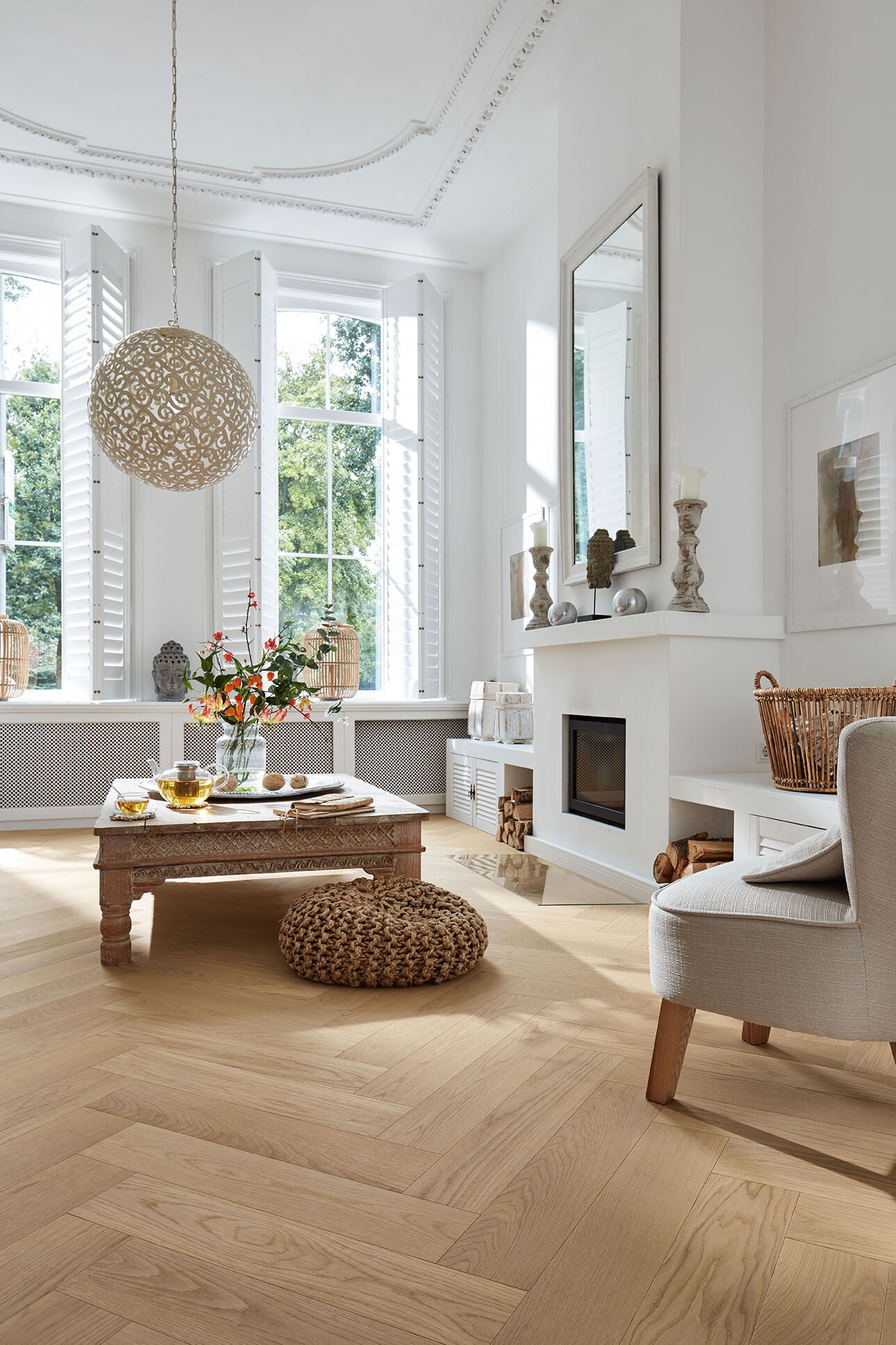 Wohnzimmer mit Kamin und Sitzmöbeln auf Fischgrät-Parkettboden