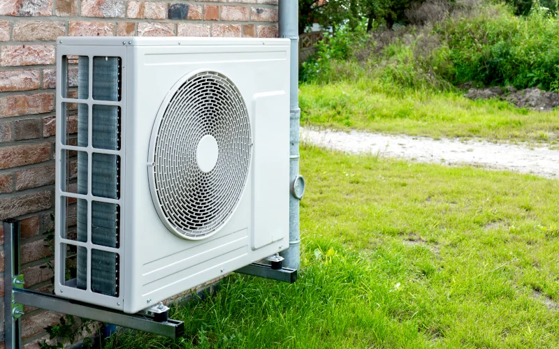Wärmepumpe in weiß am Haus stehend