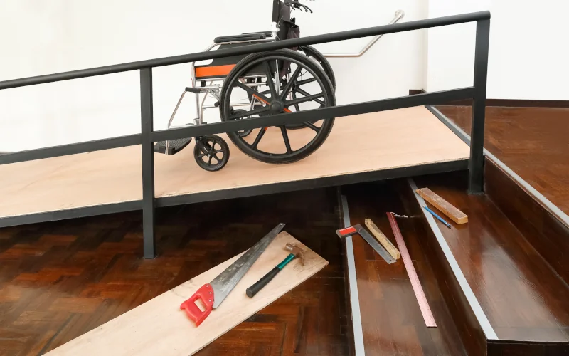 Rampe für Rollstühle an einer normalen Treppe mit Werkzeug daneben