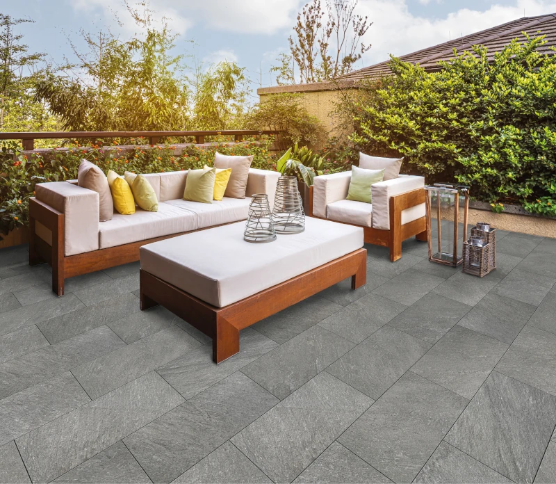 Terrasse mit hellgrauen Platten und Sitzmöbeln