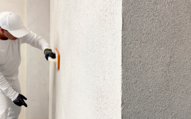 Handwerker bringt die Oberschicht auf einer zuvor gedämmten Wand an