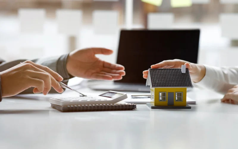 Diskussion über Immobilienfinanzierung mit Modellhaus.