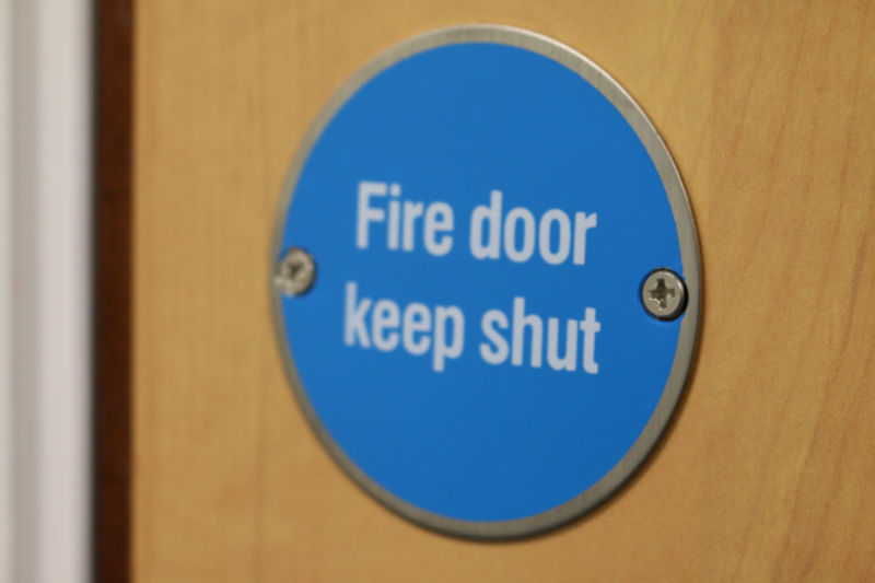 Fire door keep shut-Schild auf einer Holztür